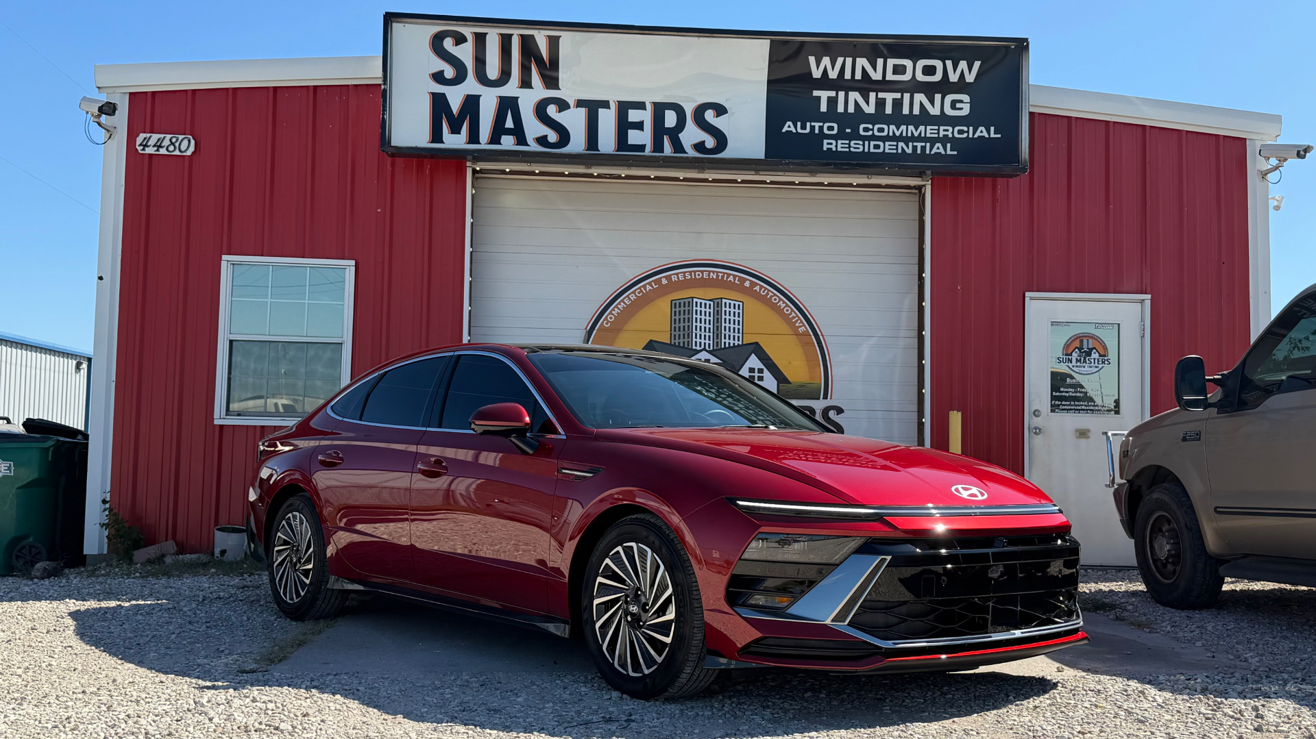 Red Hyundai sedan with professional window tinting at Sun Masters