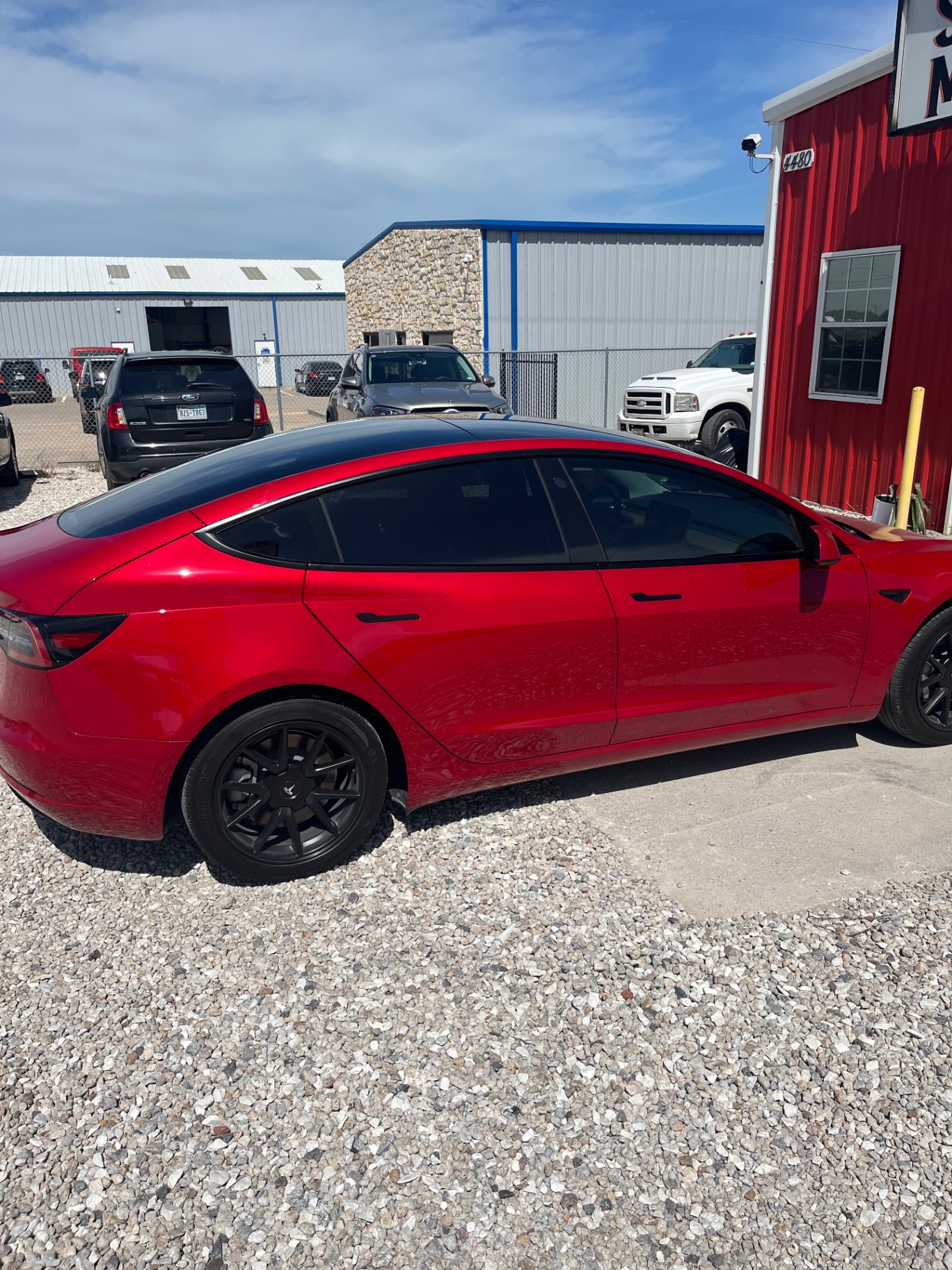 Red Tesla Model 3 side view with window tinting