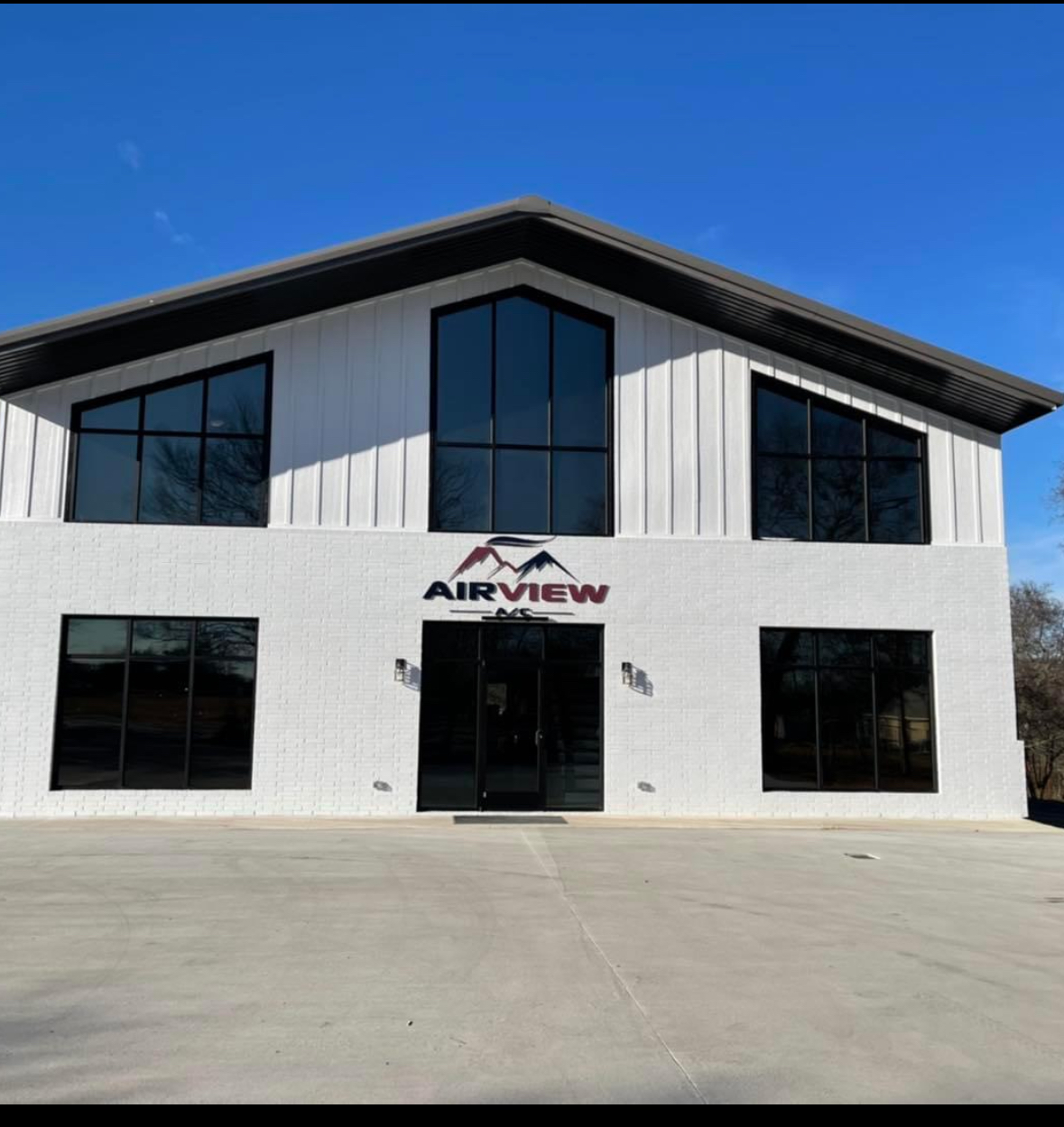 Airview AC modern white brick building with tinted windows