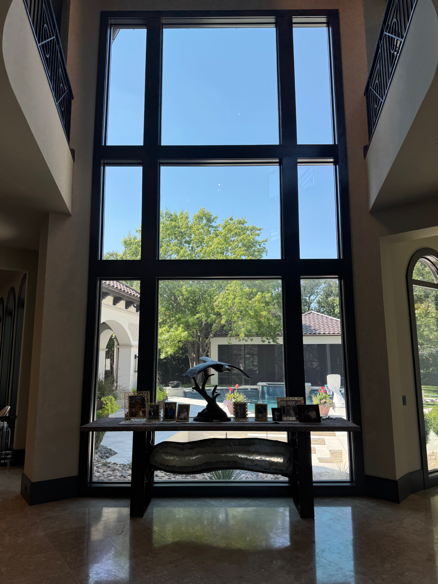 Floor-to-ceiling windows with tinting overlooking pool area