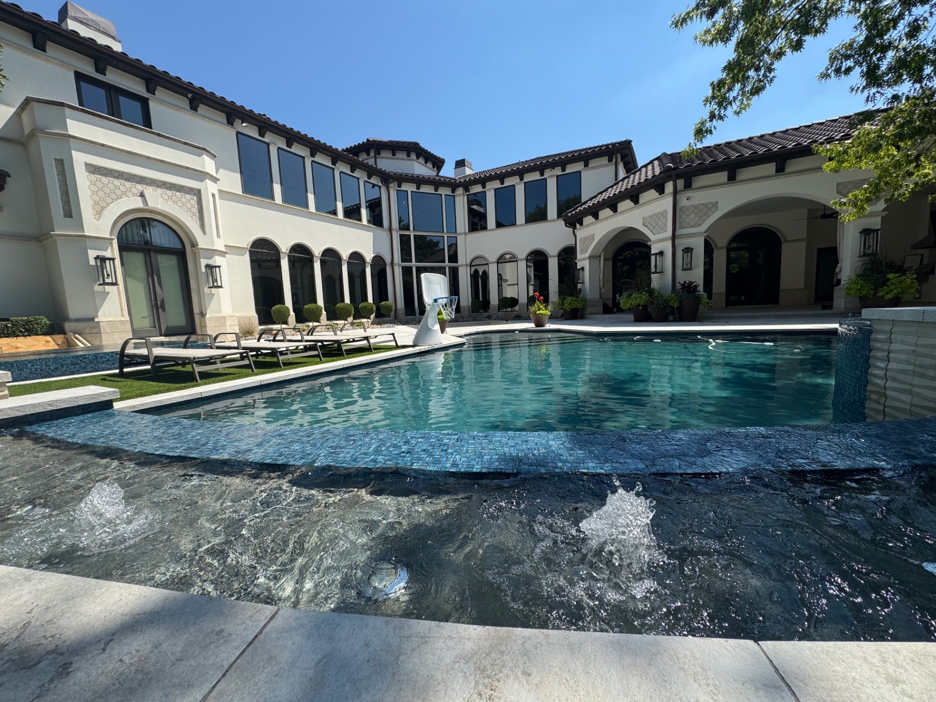 Luxury Mediterranean estate with tinted windows poolside