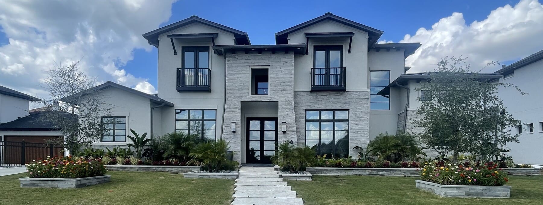 Contemporary stone home with tinted windows and landscaping